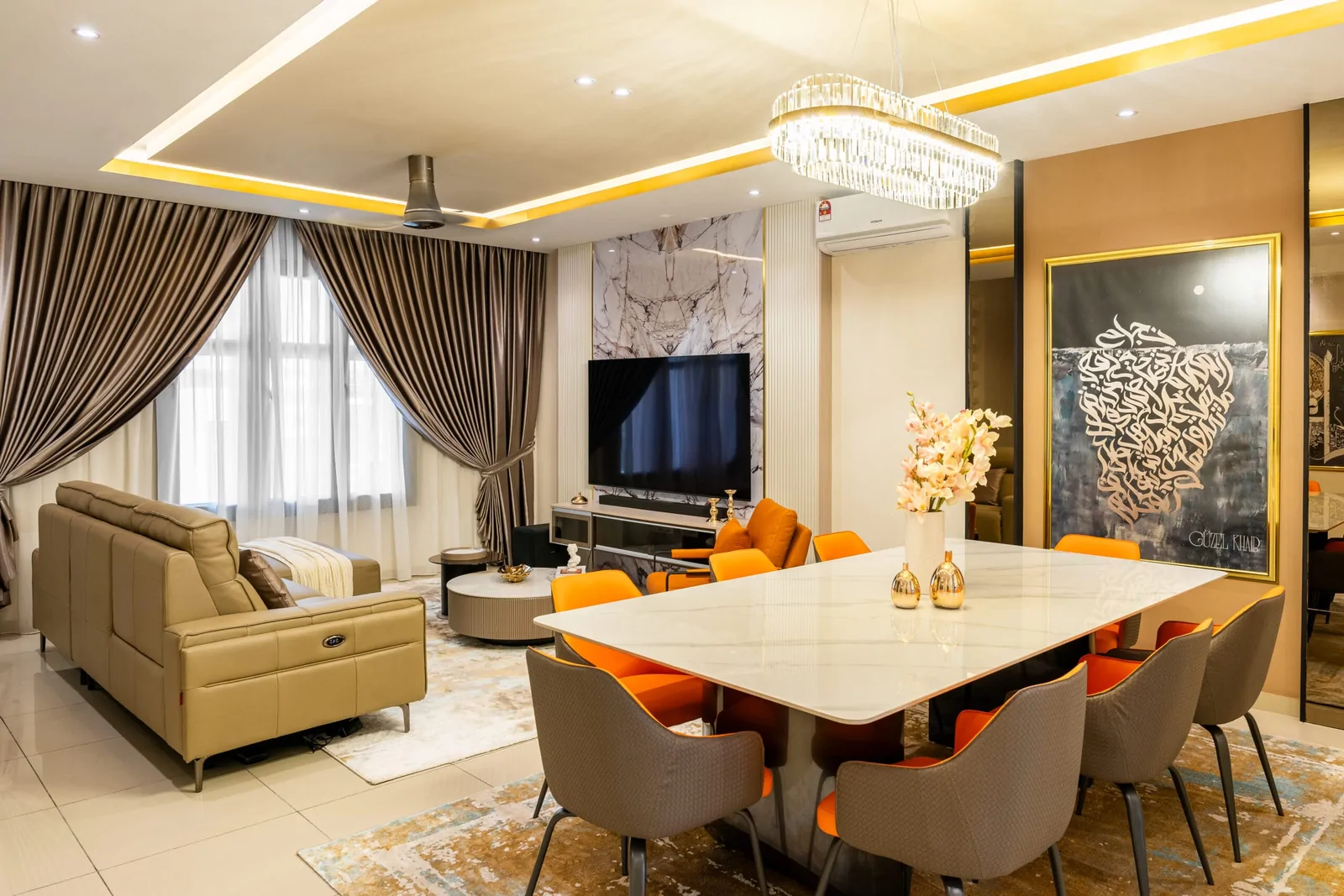 Open-plan living and dining area in a terrace house, with a stone table, orange and grey chairs and calligraphy artwork, Serimba Residence, Kajang, Malaysia, by Blaine Robert Design