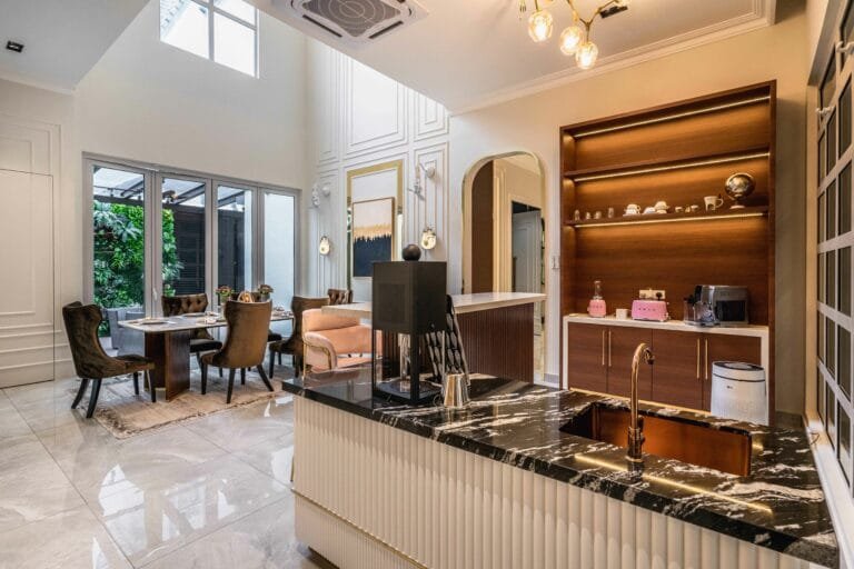 Dining area beside a coffee counter with lit timber shelving and a stone-topped island, EcoSpring, Johor Bahru, Malaysia, by Blaine Robert Design