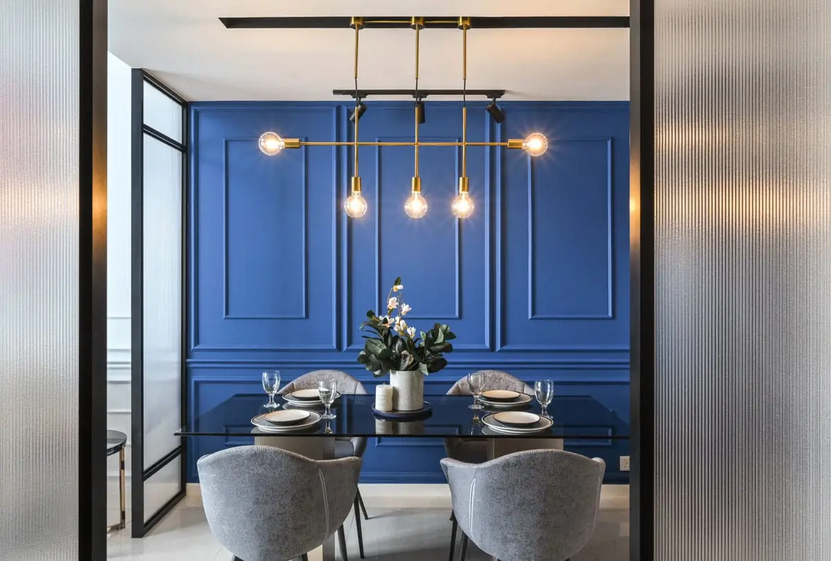 Dining room with a blue panelled accent wall, a brass linear pendant and fluted glass screens, Dorsett Hartamas show unit, Kuala Lumpur, Malaysia, by Blaine Robert Design